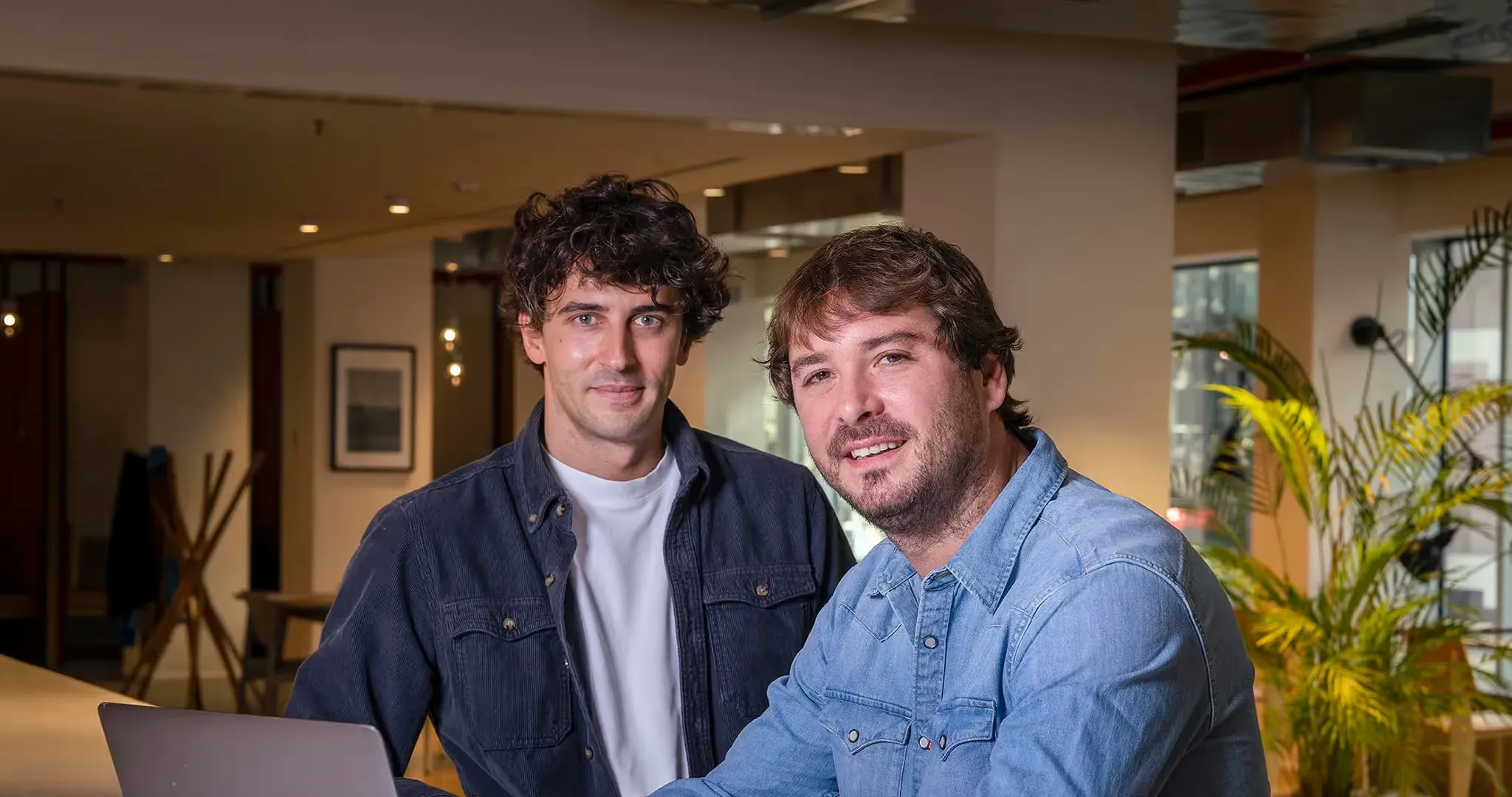 Mario Parteli and Paul Guillemin, Volta's co-founders, seated together in an office, smiling at the camera